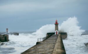 Lighthouse standing against a storm at sea, symbolizing clarity, signal detection and leadership communication amid noise.